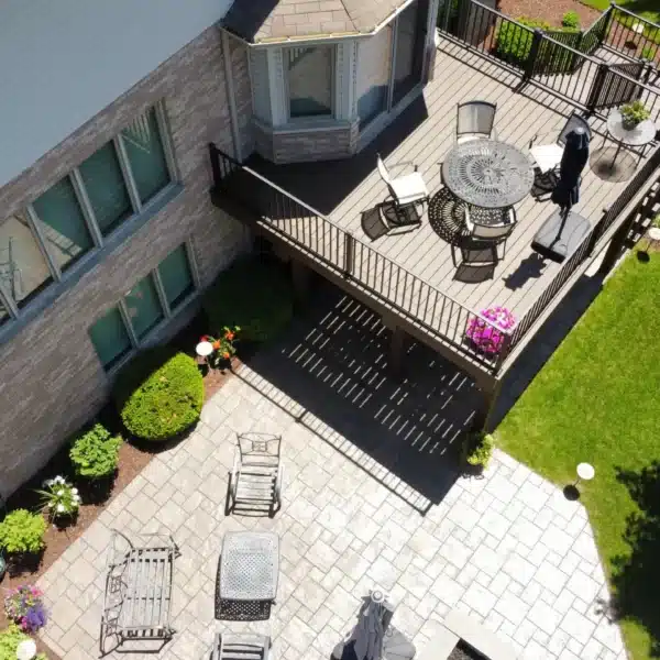 aerial view of a multi-level deck with outdoor furniture and a paver patio