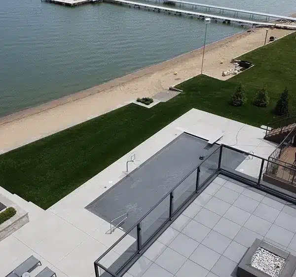 photo looking down from rooftop patio of the lakefront property, second story deck, and a ground-level fire pit.