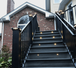 elegant black stair design for elevated decks, featuring sophisticated top post lighting embedded within the stairs and additional step lights for safety and ambiance.