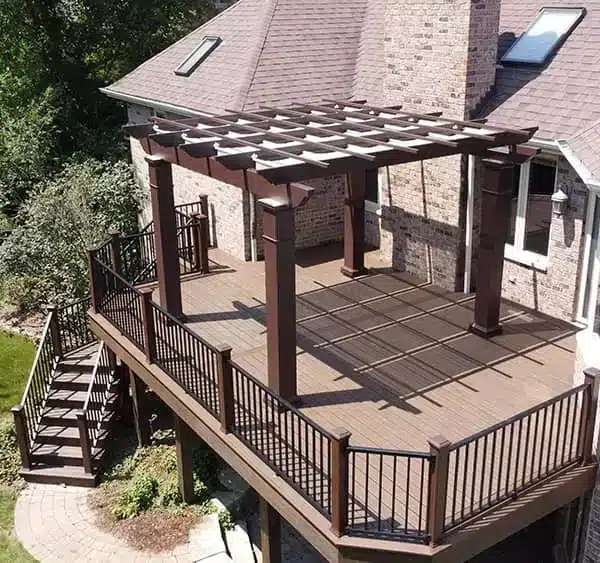 photo of a composite deck and pergola with a retractable canopy and steps leading to the ground